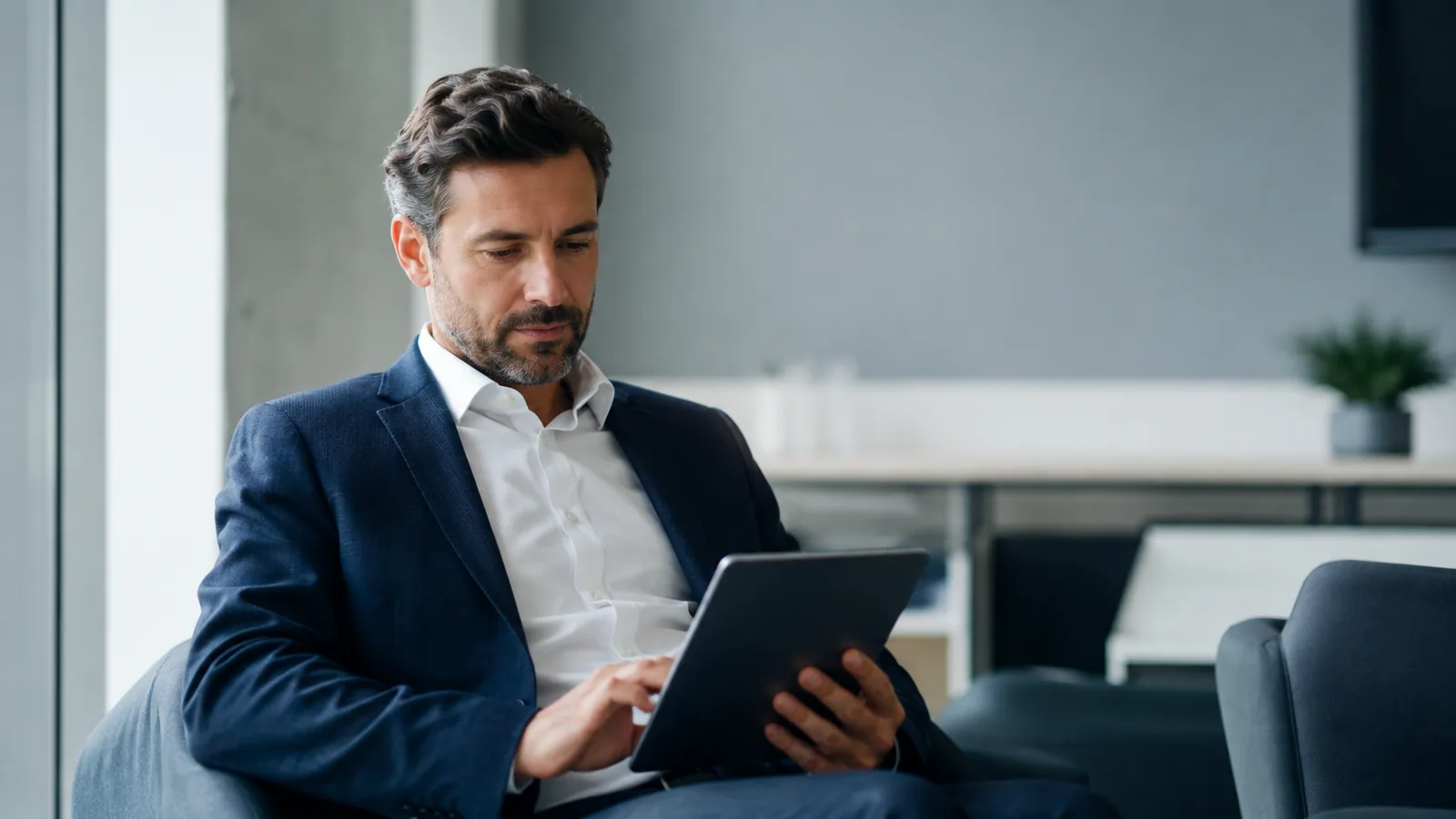 Professional bekijkt aandachtig inzichten op een tablet in een licht kantoor.